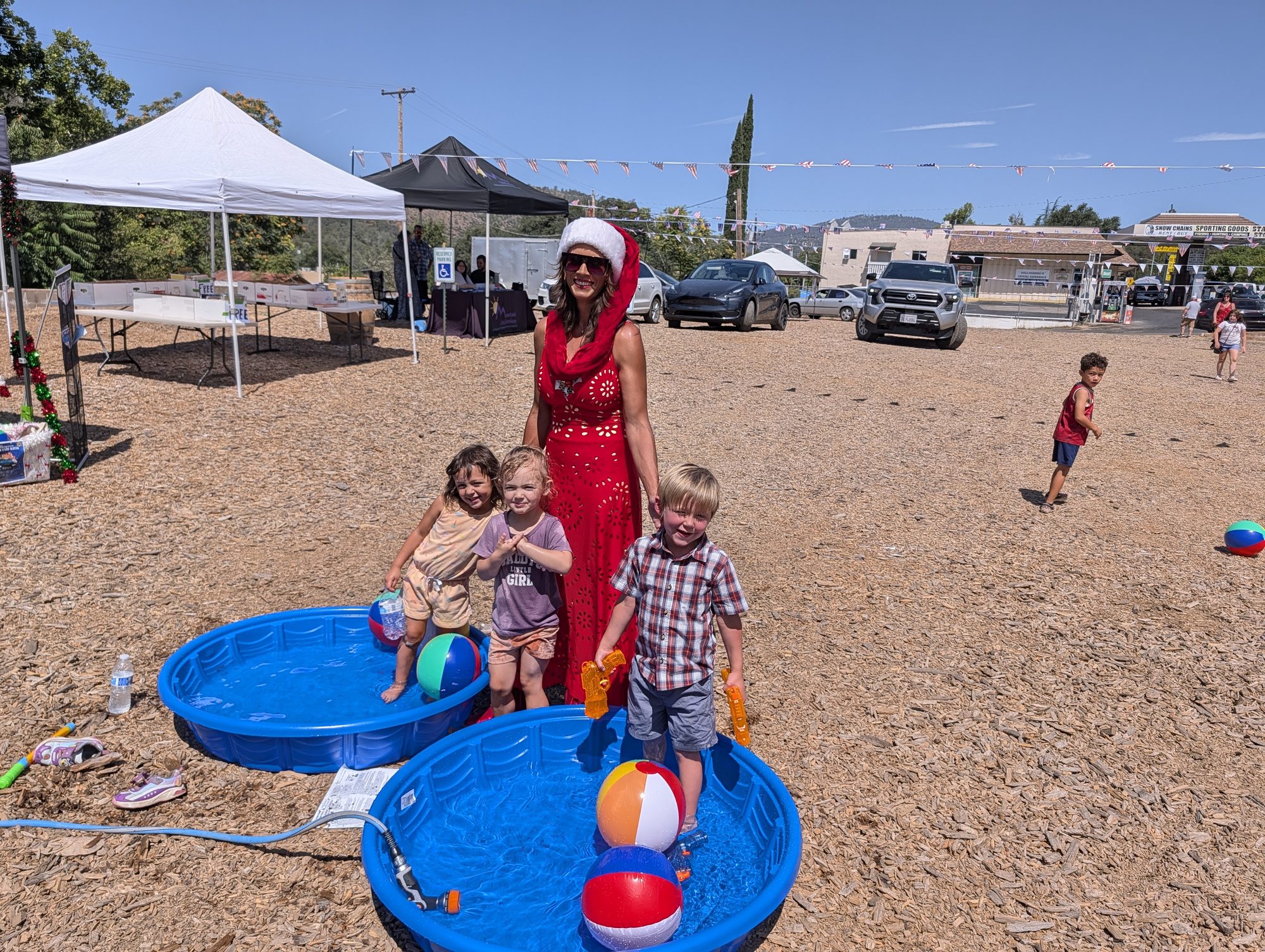 Santa in July — kiddie pools and beach balls for the little ones.